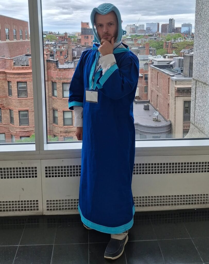 Ferdinand from Ascendance of a Bookworm by the window tilting head to the side.